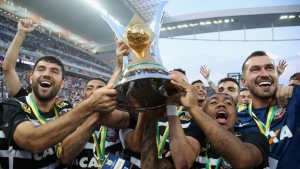 Malcom (derecha) sujetando el trofeo que acredita al Corinthians como el campeón de la Liga Brasileña en la temporada 2015. Imagen procedente de: img.fifa.com